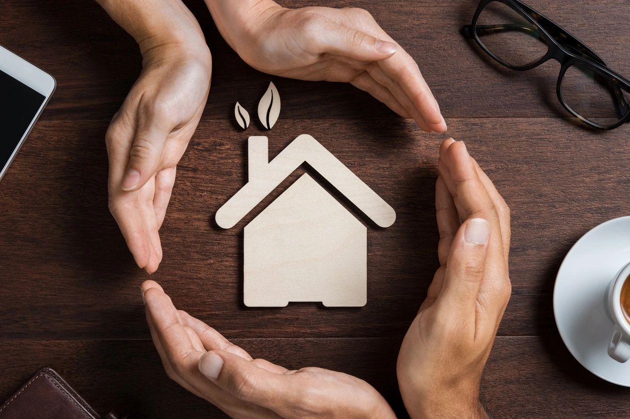 Caring hands holding house model