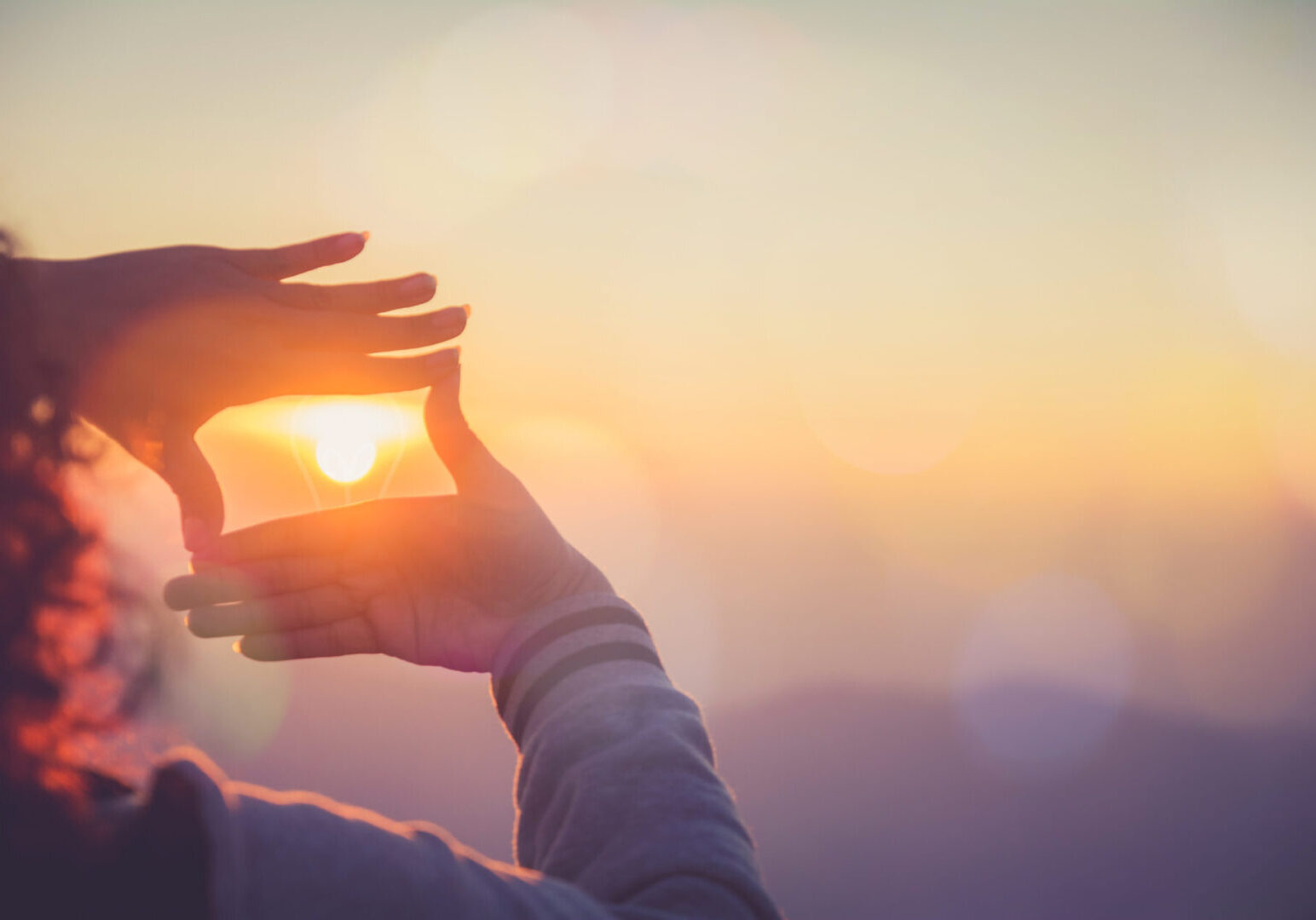 The woman making frame round the sun with her hands in sunrise,Future planning idea concept.