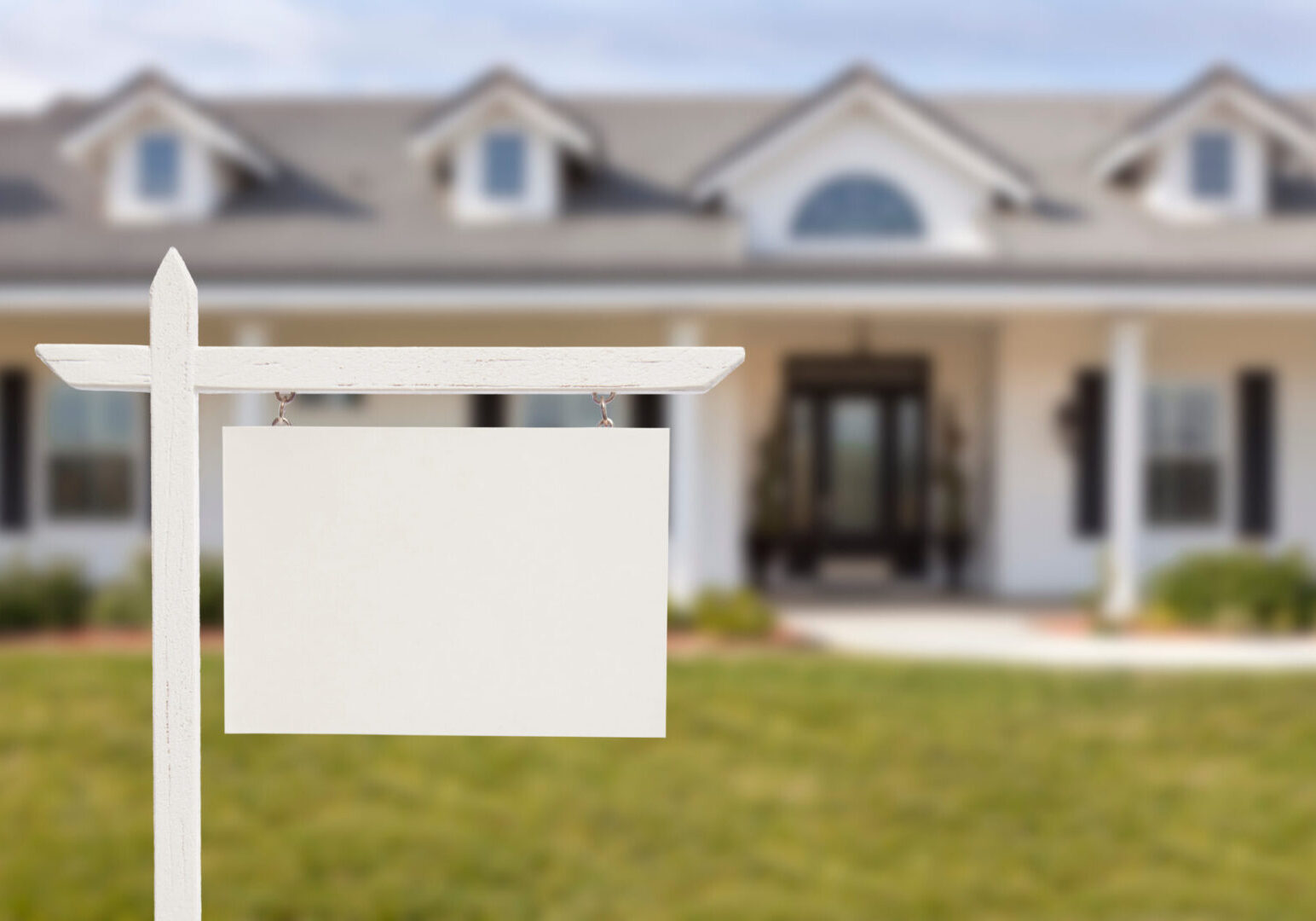 Blank Real Estate Sign in Front of Beautiful New House.